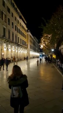 Korfu Kasabası 'nda Geceleyin Liston Gezisi boyunca Tarihi kemerler ve tatil ışıklarıyla yürümek Yunanistan' ı aydınlatıyor