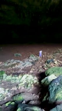 Girişten içeri giren engebeli arazi ve ışıkla, gizemli yeraltı jeolojisi ve dalgalanış macerasıyla, doğal bir kaya mağarasının karanlık iç kısımlarını araştırıyoruz.