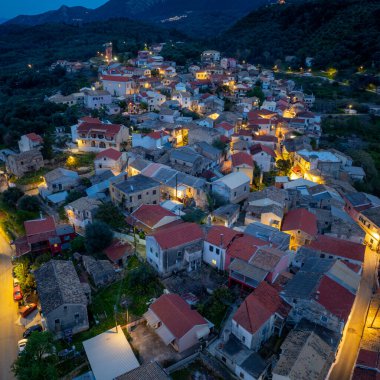 High angle aerial view over Nymfes village square and church in Corfu Greece featuring traditional buildings and scenic nature
