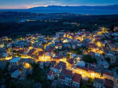 Nymfes köyünün gece ışıkları ve çevresindeki tepelerin yüksek irtifa görüntüsü, Yunanistan 'ın Korfu kentindeki atmosferik çekim