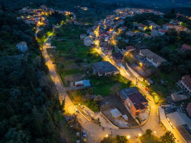Geleneksel Nymfes köyüne giden aydınlık caddenin gece görüntüsü, Yunanistan 'ın Korfu kentindeki manzaralı seyahat merkezi