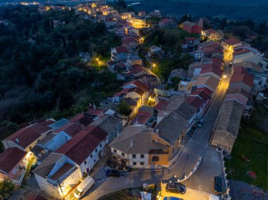Akşam karanlığında Korfu Yunanistan 'ın Agrafoi köyünün hava panoramik manzarasında, aydınlık, dolambaçlı sokaklar, geleneksel mimari ve mavi saatte tepeler yer alıyor