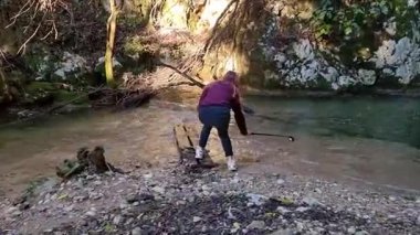 Tahta bir Plank üzerinde Bir Kadın Selfie Çubuğu Tutarak Dereyi Geçiyor, Doğada Macera, Korfu, Yunanistan