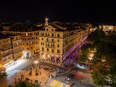 Korfu Kasabası 'ndaki ünlü Liston gezinti güvertesinde mor Paskalya ışıkları, kalabalık kafeler ve Spianada Meydanı boyunca tarihi Venedik mimarisi yer alıyor.