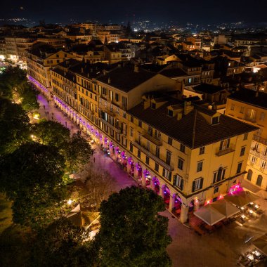 Korfu Kasabası 'ndaki ünlü Liston gezinti güvertesinde mor Paskalya ışıkları, kalabalık kafeler ve Spianada Meydanı boyunca tarihi Venedik mimarisi yer alıyor.