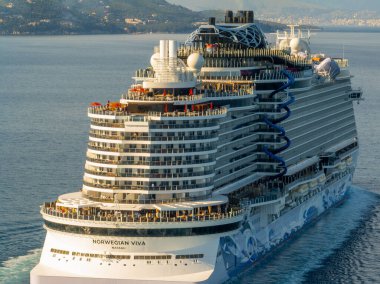 İyon Denizi 'nde seyreden devasa Norveç Viva yolcu gemisinin havadan arka görüntüsü Korfu Yunanistan' da yaz tatili sırasında kıç tasarımı, su kaydırakları ve yolcu güvertelerini gözler önüne seriyor..