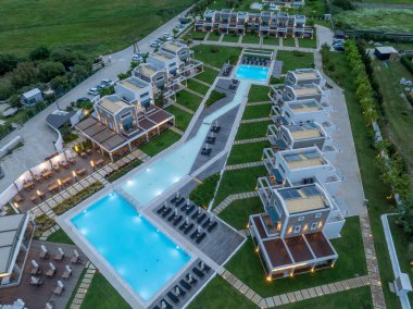 Korfu Yunanistan 'da yüzme odaları ve turkuaz havuzları olan lüks ve modern bir otel tatil beldesinin havadan aşağı manzarası
