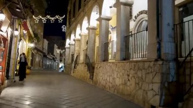 Dekoratif ışıklarla aydınlatılmış sessiz bir sokak.