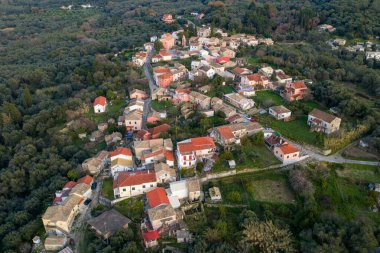 Agioi Douloi köyü Korfu Yunanistan 'daki geleneksel mimarinin havadan görünüşü yemyeşil zeytin korulukları ve tepelerle bezenmiştir