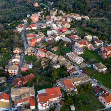 Kuzey Korfu 'daki Agioi Douloi köyünün panoramik hava aracı görüntüsü Yunanistan' ın altın saat boyunca yemyeşil zeytin ağaçları ile çevrili