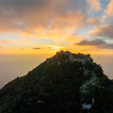 Angelokastro Bizans şatosunun havadan görünüşü, Yunanistan 'ın Korfu adasındaki İyon Denizi suyunun parlak güneş yansıtma yoluna sahip altın günbatımına karşı siluet şeklinde harabeler, dramatik manzara.