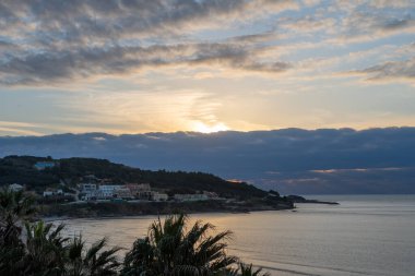 Agios Stefanos Korfu Yunanistan 'daki dramatik Bulutlar ve Sakin Deniz Koyu ile Sunset' teki Kıyı Köyü 'nün Panoramik Manzarası