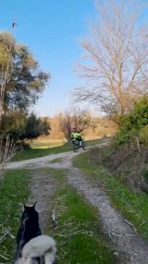 Kirli yolda motosiklet süren biri.