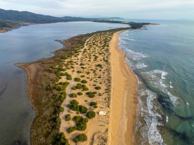 Halikounas Sahili 'nin ve Korfu Yunanistan' daki Korission Gölü 'nün insansız hava aracı görüntüsü. Kum tepeleri ve sedir ormanlarıyla dolu vahşi kumlu sahil şeridi İyon Denizi 'ni lagün doğasından ayırıyor..