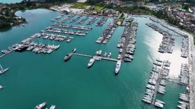 Korfu Yunanistan 'daki büyük Gouvia Marina altyapısının geniş panoramik hava aracı görüntüsü, yüzlerce demirlemiş yatla geniş liman manzarası ve parlak güneş altında kıyı mimarisi