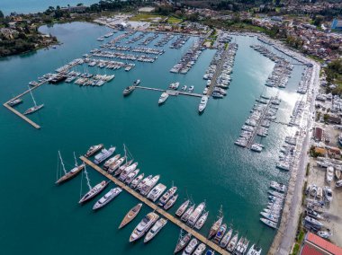 Yunanistan 'ın Corfu kentinde yelkenli yatlar ve teknelerle dolu Gouvia Marina' nın panoramik hava aracı görüntüsü. Büyük liman altyapısı ve deniz manzarası