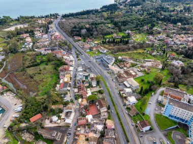 Yunanistan 'ın Corfu kentindeki Gouvia' dan geçen Ethniki Odos Palaiokastritsis otoyolunun havadan görünüşü, açık ve güneşli bir yaz gününde Akdeniz adasında önemli bir ulaşım arteri ve kıyı yolu..