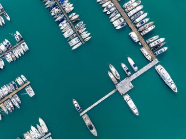 Korfu Yunanistan 'daki Gouvia Limanı' nın üst düzey insansız hava aracı görüntüsü lüks yatları ve tekneleri turkuvaz İyon Denizi 'ndeki rıhtımlarda, soyut deniz düzeni, Akdeniz limanı, seyahat ve yelkencilik konsepti