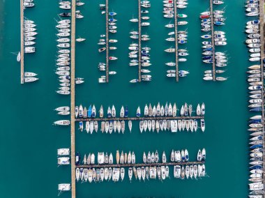 Korfu Yunanistan 'daki Gouvia Limanı' na yanaşan teknelerin tepeden aşağıya bakan görüntüsü, lüks gemilerle dolu renkli su ve rıhtımlar, Akdeniz 'deki ünlü Yunan yelken merkezi ve turistik eğlence merkezi