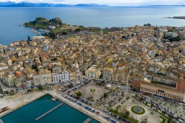 Yunanistan 'ın Kerkyra kentindeki tarihi Korfu Eski Kasabası, Venedik mimarisi, Eski Kale, terasotta çatıları ve bulutlu bir UNESCO dünya mirası altındaki manzaralı İyon Denizi kıyı şeridi manzarası