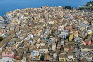 Yunanistan 'ın Kerkyra kentindeki tarihi Korfu Eski Kasabası' nın hava manzarasında Venedik mimarisi, terasotta çatıları ve manzaralı İyon Denizi kıyı şeridi yer alıyor..