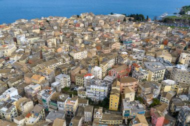 Yunanistan 'ın Kerkyra kentindeki tarihi Korfu Eski Kasabası' nın hava panoramik manzarası, renkli Venedik tarzı mimari, terracotta çatıları, ikonik Aziz Spyridon Kilisesi çan kulesi ve manzaralı İyon Denizi kıyı şeridi UNESCO Dünya Mirası