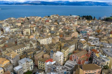 Renkli Venedik mimarisi, terasotta çatıları, Aziz Spyridon çan kulesi ve manzaralı İyon Denizi kıyı şeridinin yer aldığı Yunanistan 'ın Kerkyra kentindeki tarihi Korfu Eski Kasabasının panoramik manzarası.