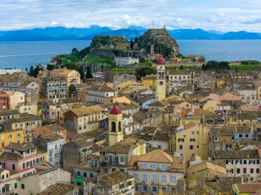Korfu Eski Kasabası ve Eski Kale 'nin (Palaio Frourio) havadan panoramik görüntüsü. Saint Spyridon Kilisesi 'nin ikonik kırmızı çan kulesi, yoğun Venedik binaları ve Yunanistan' ın Kerkyra kentindeki mavi İyon Denizi 'nin insansız hava aracı görüntüleri