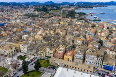 Yunanistan 'ın Kerkyra kentindeki tarihi Korfu Eski Kasabası' nın hava panoramik manzarasında renkli Venedik tarzı mimari, terracotta çatıları, Saint Spyridon çan kulesi ve devasa Yeni Kale yer alıyor..