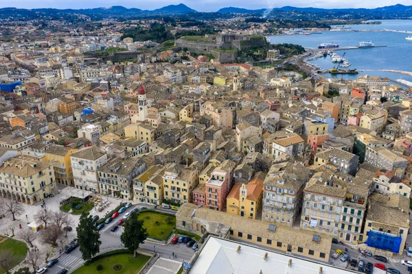 Yunanistan 'ın Kerkyra kentindeki tarihi Korfu Eski Kasabası' nın hava panoramik manzarasında renkli Venedik tarzı mimari, terracotta çatıları, Saint Spyridon çan kulesi ve devasa Yeni Kale yer alıyor..