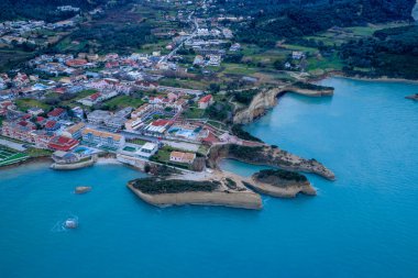 Sidari ve Yunanistan 'ın Korfu kentindeki ünlü Kanal d' Amour 'un havadan panoramik manzarası: Turkuaz sular, eşsiz kaya oluşumları ve geleneksel bir sahil beldesi içeren Akdeniz sahili kıyı şeridi.