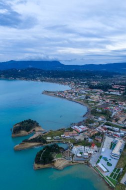 Yunanistan 'ın Korfu adasındaki ünlü Canal d' Amour kaya oluşumlarının ve Sidari köyünün panoramik görüntüsü. Turkuaz İyon Denizi suları ve alacakaranlıkta dramatik uçurumları olan güzel kıyı manzarası.