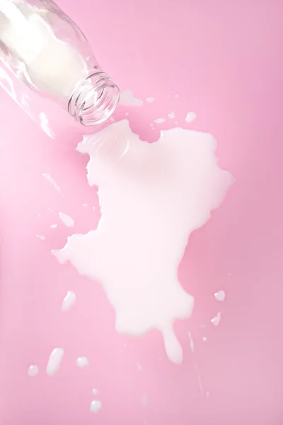 pembe bir arka plan üzerinde dökülen süt 