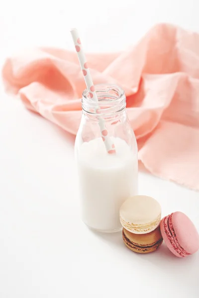 Macaroons diferentes com garrafa de leite — Fotografia de Stock