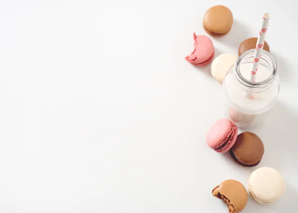 Macaroons diferentes com garrafa de leite — Fotografia de Stock