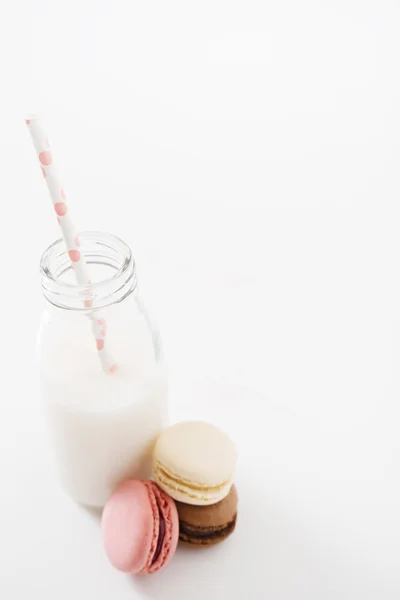 Macaroons diferentes com garrafa de leite — Fotografia de Stock
