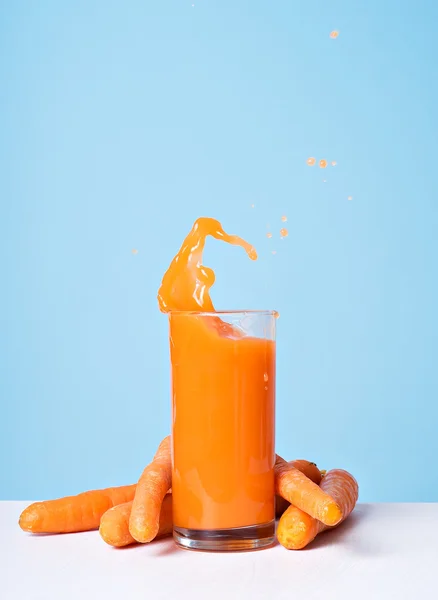 Colorido jugo de zanahoria fresca salpicadura en vidrio — Foto de Stock