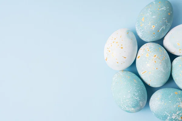 Barevné velikonoční vajíčka na modrém pozadí — Stock fotografie