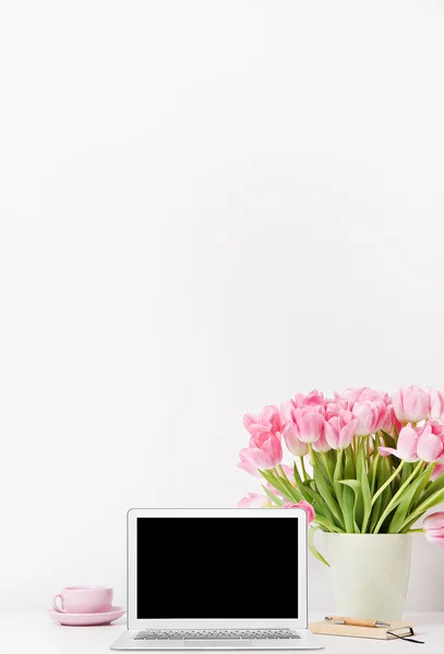 白い背景上のコンピューターと新鮮な春ピンクのチューリップ — ストック写真