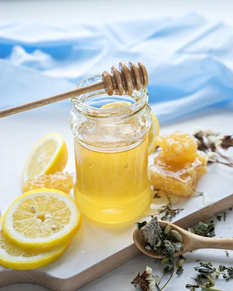 Miel en tarro con cazo de miel, limón y té —  Fotos de Stock