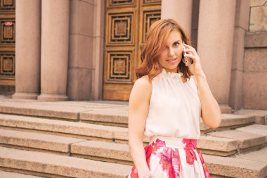 Genç bir kadın cep telefonuyla konuşuyor.