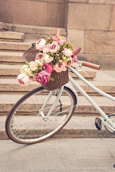 Vintage dziewczyny bicyclewith kwiaty w koszyku — Zdjęcie stockowe