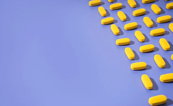 Conceito theme.bright pílulas amarelas no fundo azul — Fotografia de Stock