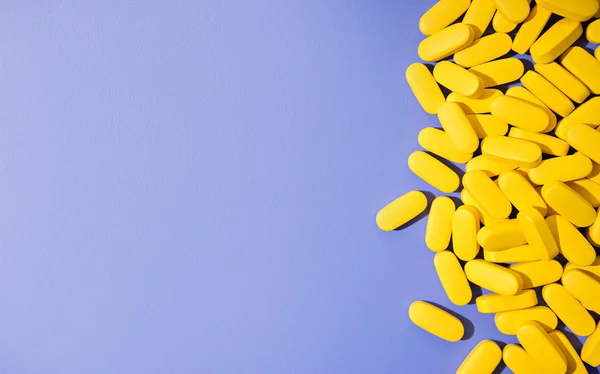 Conceito theme.bright pílulas amarelas no fundo azul — Fotografia de Stock