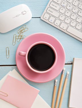 Ofis resepsiyon masası bilgisayar, sarf malzemeleri ve kahve fincanı ile