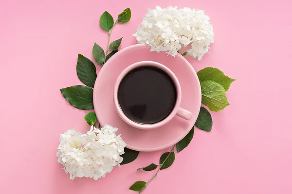 Šálek kávy s květy růžové tabulka — Stock fotografie