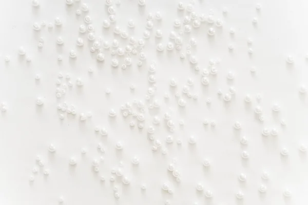 A lot of white beads on white background — Stock Photo, Image
