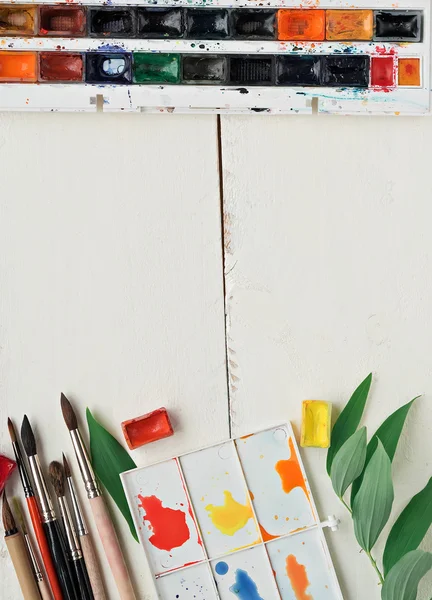 Lugar de trabajo del pintor con paleta de acuarela y otras herramientas — Foto de Stock