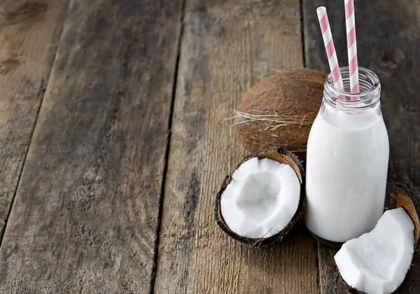 Coco com leite de coco na mesa de madeira — Fotografia de Stock