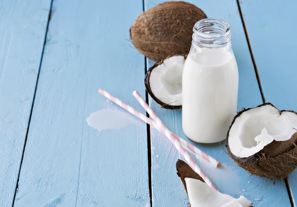 Cocos con leche de coco sobre mesa de madera —  Fotos de Stock